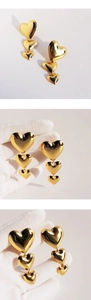 Gros plan de boucles d'oreilles pendantes à trois cœurs dorés avec finition miroir