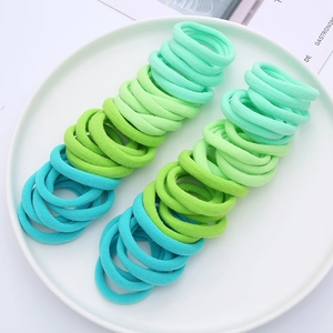 Macro shot of seamless elastic hair bands in vibrant gradient green colors set in a tray