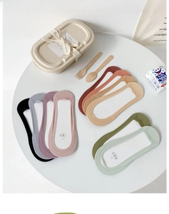 Flat lay of seamless no-show socks in various pastel colors on a stylish white table