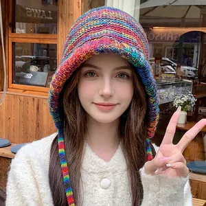 Rainbow striped knit beanie hat with ear flaps and colorful straps for a cozy autumn look