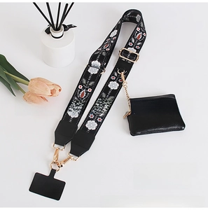 Detail of floral embroidery on black phone strap with matching mini pouch and gold hardware