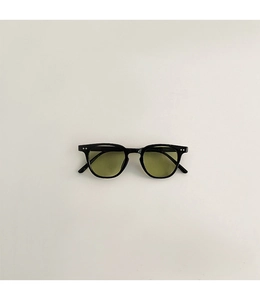Détail de lunettes de soleil vintage pour enfants avec cadre noir et verres vert olive