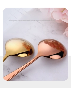 Détail de cuillères en acier inoxydable poli miroir or et or rose sur du marbre