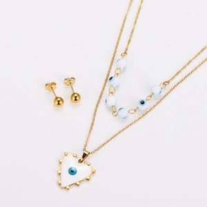 Detail of gold double-layer necklace with white evil eye beads and matching stud earrings