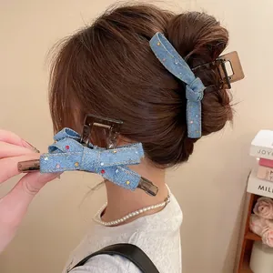 Denim bow hair claw clip with colorful rhinestones on a female model in casual style