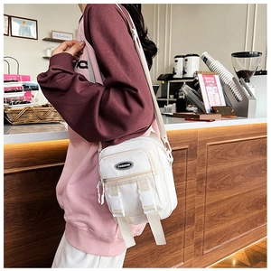Borsa a tracolla in nylon bianco con patta a doppia fibbia e tracolla regolabile su modella