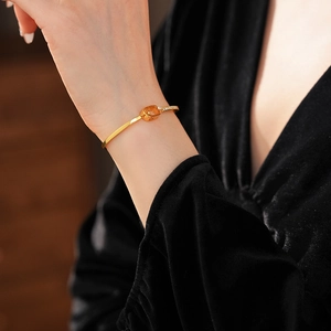 Close-up of 18k gold plated bracelet with zircon square charm on a model wrist