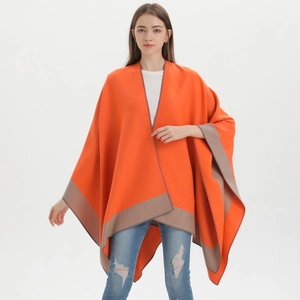 Detailed view of soft orange knitted shawl with contrast brown trim and split cape design