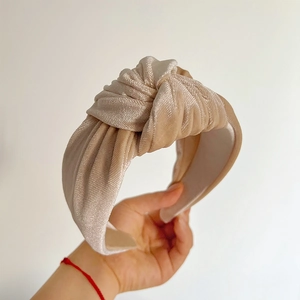 Detail showing the champagne ribbed velvet fabric and decorative knot on the wide headband