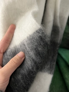 Close-up of thick gradient mohair scarf showing soft knit texture and plush gray-white fabric