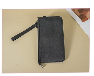 Close-up of black textured leather long wallet with wrist strap and metal zipper detail