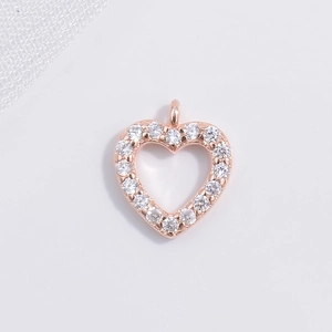 Detailed macro view of heart-shaped rose gold pendant with sparkling white cubic zirconia