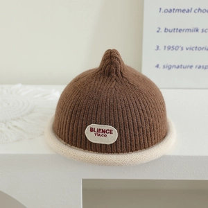 Detail of baby knit beanie with ribbed texture and rolled brim in brown and cream colors