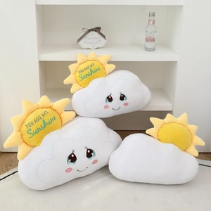 Detail of plush sun cloud pillow featuring cute facial embroidery and sunshine text