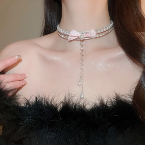 Detail of double-layer choker with pink bow, pearl tassels, and sparkling crystal charms