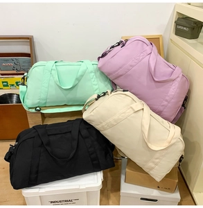 Collection of colorful large capacity travel duffel bags in mint, purple, and cream