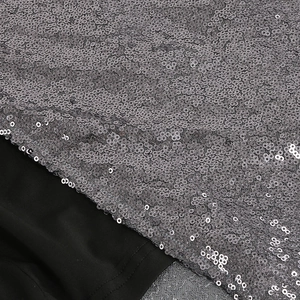 Vue détaillée des paillettes argentées haute densité sur tissu noir pour robe de soirée