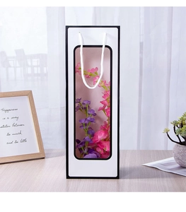 White wine gift bag with clear window and handles shown on a wooden table setup