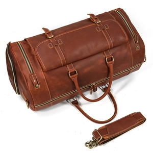 Close-up of deep brown leather travel bag featuring brass hardware and shoulder strap details