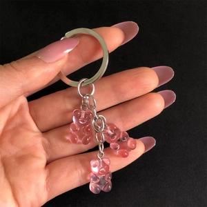 Detailed close-up of three pink translucent jelly bear charms on a metal keychain