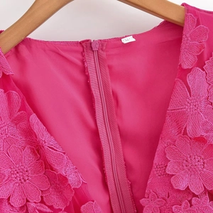 Détail de la robe fuchsia avec broderies florales 3D et fermeture éclair invisible au dos