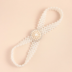 Detail of elegant pearl waist chain with rhinestone buckle on pink texture background