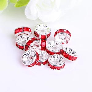 Macro detail of silver alloy spacer beads with sparkling red rhinestones for DIY jewelry