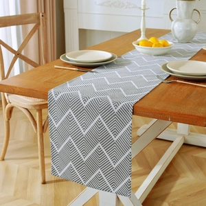 Detail of gray geometric pattern table runner on a wooden table in a home setting