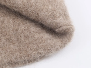 Dettaglio macro della trama in maglia beige con fibre di lana mohair di alta qualità