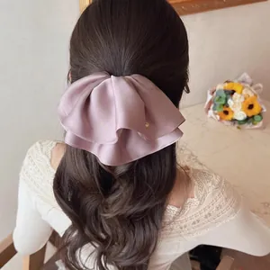 Elegant dusty pink satin bow hair claw clip for ponytail style with golden metal charm