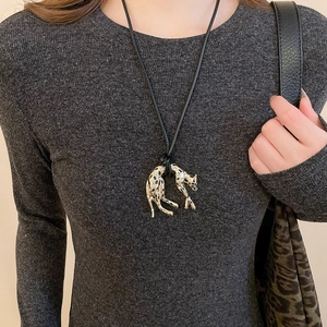 Detail of a golden leopard pendant with crystal accents on a retro leopard print necklace