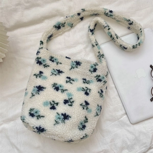 Detailed texture of white fleece crossbody bag featuring a delicate blue floral pattern