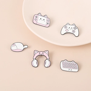 Close-up of pink cat-themed enamel pins featuring game console and headset designs