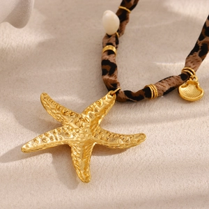 Detail of 18K gold starfish pendant on leopard print fabric cord with shell charm