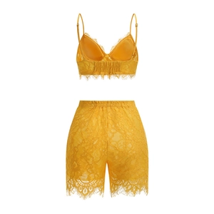 Dettaglio del top a canotta in pizzo giallo e degli shorts coordinati con pizzo