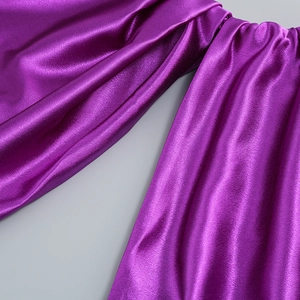 Vue détaillée du tissu satiné violet magenta montrant une texture brillante et un drapé élégant