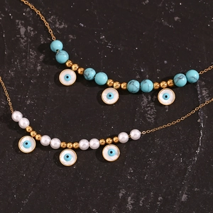 Close-up of bohemian evil eye necklaces with turquoise and white pearl beads in gold