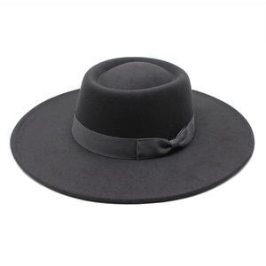 Détail d'un chapeau en laine noir à large bord avec ruban satiné et petit nœud