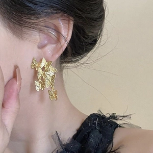 Close-up of golden vintage butterfly drop earrings shown on ear for a delicate look
