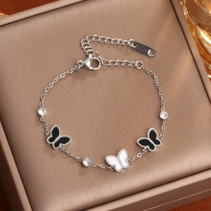 Bracelet élégant en acier titane avec breloques papillon et cristaux sur boîte à bijoux