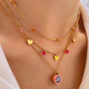 Three-layer gold necklace set with heart and star pendants featuring blue and pink gemstones