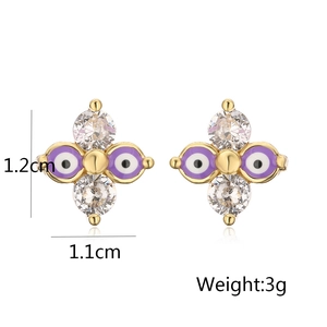 Detail view of gold-plated evil eye stud earrings with purple enamel and cubic zirconia