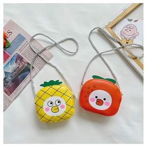Close-up of cute fruit-shaped crossbody bags in pineapple and orange styles for girls