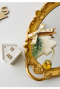 Detail of Christmas tree plush pendant with gold bell and Merry Christmas tag