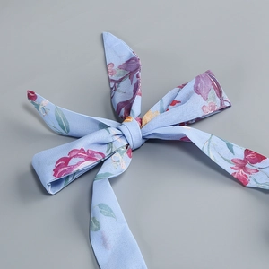 Detail eines geblümten Chiffon-Bogen-Zubehörs in Hellblau und Burgund auf Sommerkleid