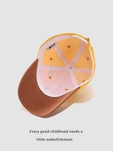 Detail of children's dinosaur cap interior with breathable lining and English quote