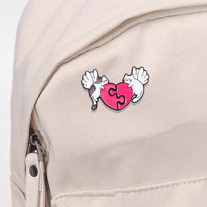 Detail of cartoon enamel pins with cat and heart puzzle on a white canvas backpack
