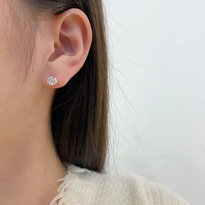 Close-up of a 925 sterling silver stud earring with a round sparkling zircon on a model