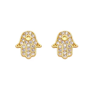 Close-up of golden Hamsa Hand stud earring with pave-set clear zircon stones on white background