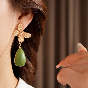 Gros plan détaillé d'une boucle d'oreille papillon vintage avec pendentif en résine verte